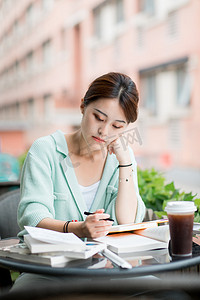 教育学习白天一个女学生户外做题摄影图配图