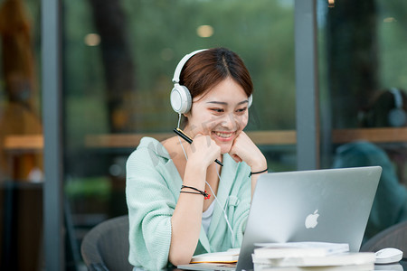 教育白天戴着耳机上网课的女孩户外托下巴摄影图配图