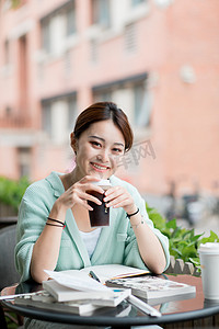 教育学习白天一个女学生户外拿着咖啡微笑摄影图配图