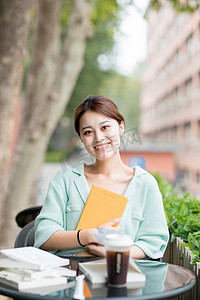 学习教育户外看书学习的女孩户外抱着书摄影图配图