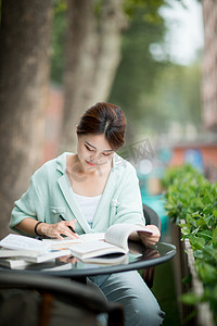 学习教育白天一个女学生户外看书做笔记摄影图配图