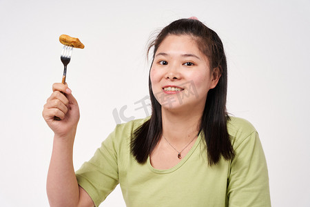 减肥误区摄影照片_减肥肥胖肥胖女孩不规律饮食喜欢吃炸鸡块摄影图配图