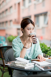 学习继续加油摄影照片_教育学系白天一个女学生户外喝咖啡摄影图配图