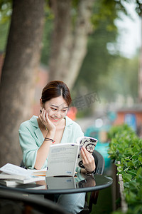 教育学习白天一个女学生户外托下巴看书微笑摄影图配图
