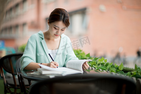 教育学习下午一个女学生户外写字做笔记摄影图配图