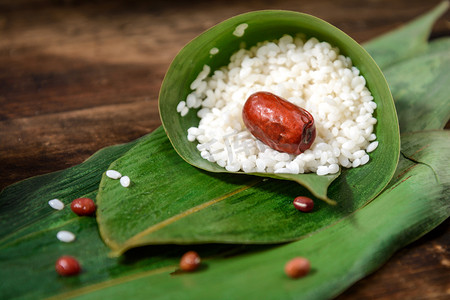 食粽子摄影照片_美食端午节粽子绿色粽叶摆放摄影图配图