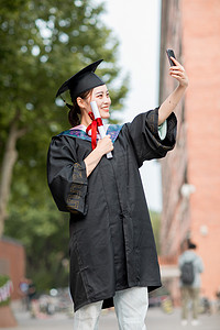 毕业季白天穿着学士服的美女毕业生户外自拍视频摄影图配图