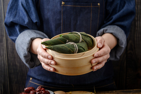 粽子摄影照片_美食端午节粽子人手端着摄影图配图