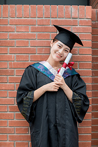 毕业季白天穿着学士服的美女毕业生教学楼外摆拍摄影图配图