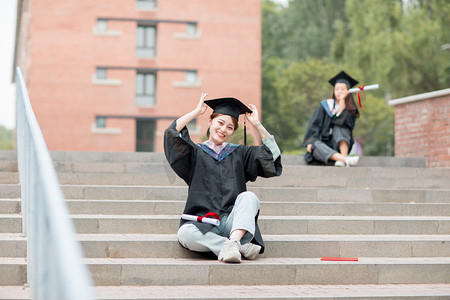 毕业摄影照片_毕业季白天穿着学士服的美女毕业生户外戴上学士帽摄影图配图