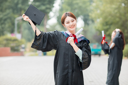 毕业季白天穿着学士服的毕业生教学楼摆拍摄影图配图