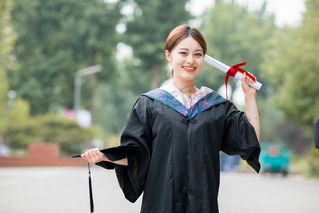 毕业摄影照片_毕业季清晨穿着学士服的美女毕业生户外摆拍摄影图配图