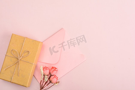 我的中国梦背景摄影照片_节日白天信封礼物盒粉色背景摆放摄影图配图