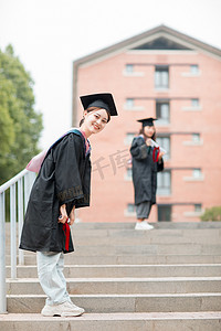 毕业季白天穿着学士服的美女毕业生户外摆拍摄影图配图