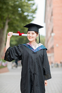 大学毕业照摄影照片_校园生活毕业白天穿着学士服的美女毕业生教学楼外摆拍摄影图配图