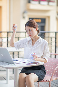 商务白天生气的商务女士户外揉纸团摄影图配图