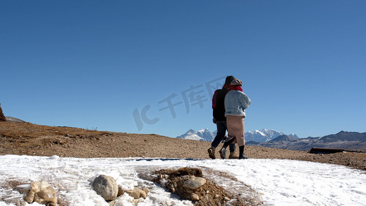 情侣素材摄影照片_实拍情侣在高原雪地里行走素材