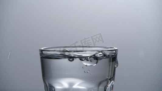 喷绘广告摄影照片_白酒酒水导入透明玻璃杯广告素材