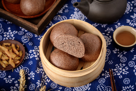 碳水食物摄影照片_美食白天黑全麦馒头青花布摆放摄影图配图