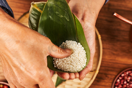 粽子摄影照片_传统美食端午传统节日粽子裹粽子摄影图配图