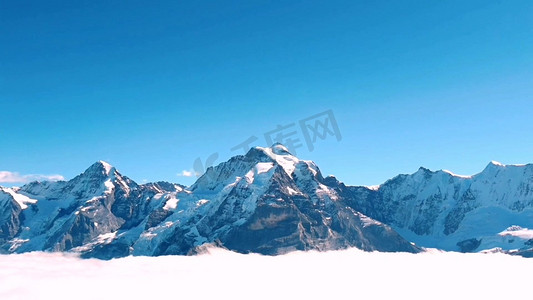 雪景摄影照片_雪山山顶云雾缭绕高清实拍