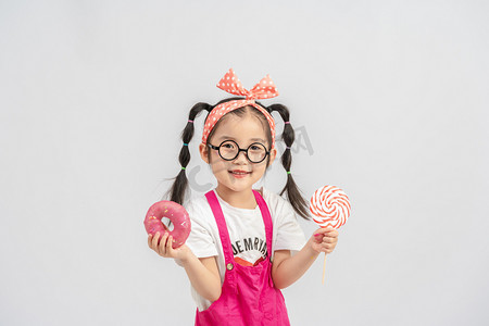 开学季摄影照片_节日白天女孩棒棒糖室内甜甜圈摄影图配图