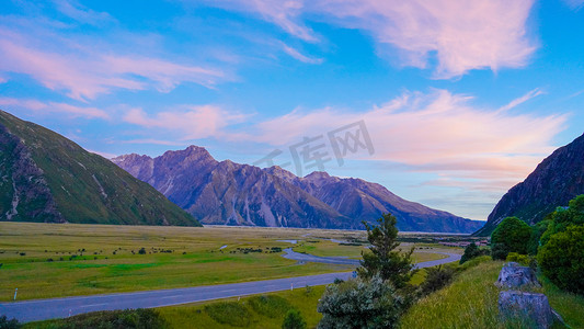 草原旅游摄影照片_晚霞雪山夕阳雪山新西兰全景画摄影图配图