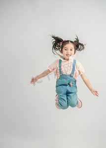 六一儿童节游园海报摄影照片_六一白天女孩室内跳跃摄影图配图