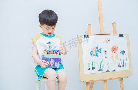 六一儿童节北京摄影照片_画画晚上孩子室内选画笔颜色摄影图配图