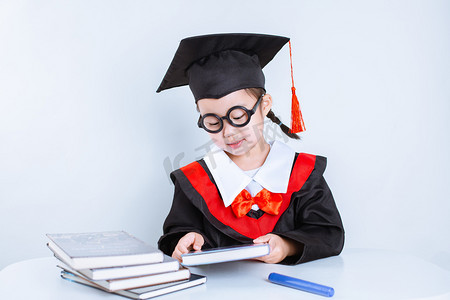 书小孩摄影照片_毕业季白天女孩白背景看书摄影图配图