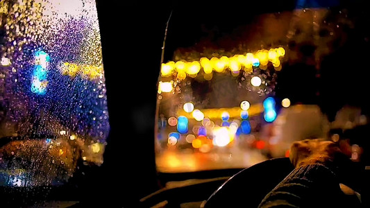 夜景灯光摄影照片_雨中道路行驶开车司机唯美灯光实拍