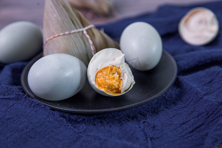 粽子叶粽子摄影照片_端午节五月初五美食咸鸭蛋摆拍摄影图配图