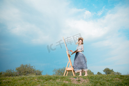 文艺摄影照片_文艺清新白天穿着萝莉裙的写生美女户外草坪望向天空摄影图配图