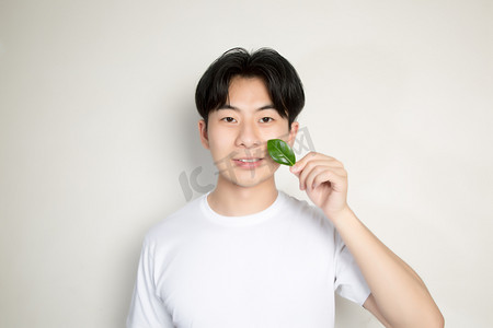 阳光男生特写肖像树叶摄影图配图