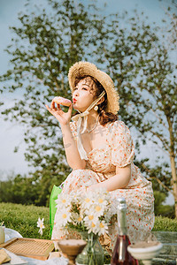 夏天文艺白天野餐的美女户外吃甜甜圈摄影图配图