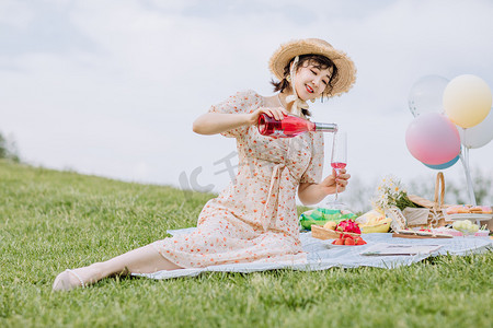 夏天文艺白天野餐美女户外倒酒摄影图配图
