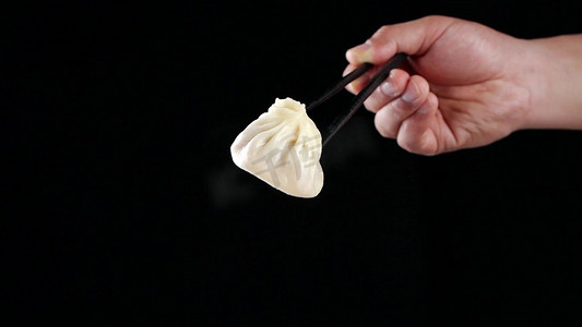 筷子夹起汤包灌汤包漏汤汁上海灌汤包小笼包