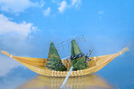 美食端午节两个粽子小船中划船摄影图配图