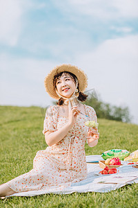 夏天文艺白天野餐的美女户外坐在草地上摄影图配图