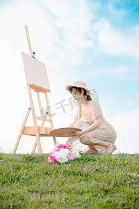 夏天文艺白天户外写生的美女草地上调色摄影图配图