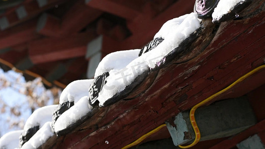 雪屋檐摄影照片_雪中的屋檐和融化的雪水