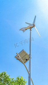 绿色环保风车摄影照片_环保新能源白天风车街道发电摄影图配图