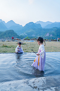 儿童风景图摄影照片_古风玩水女孩中午儿童户外度假玩水摄影图配图