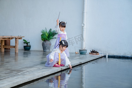 西溪诚园摄影照片_两小无猜下午女孩水边玩水摄影图配图