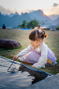 玩水的小女孩夕阳儿童户外半身摄影图配图