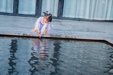 古风山水图摄影照片_玩水汉服姑娘下午儿童户外水边蹲下摄影图配图