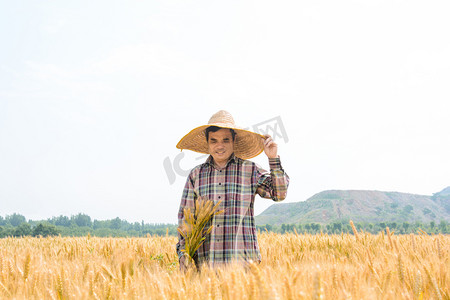 人物白天农民伯伯麦田里扶着草帽摄影图配图