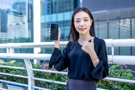 女赞摄影照片_商务人像下午白领人行桥拿着手机点赞摄影图配图