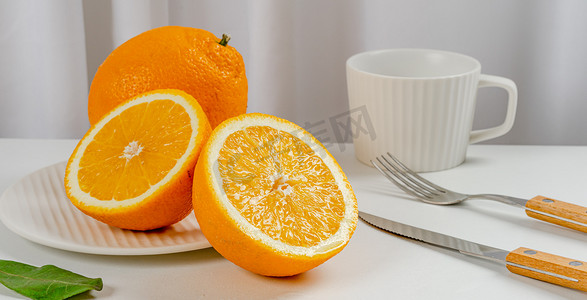 切开的摄影照片_夏天多汁水果白天切开的橙子室内餐桌静物摆拍摄影图配图