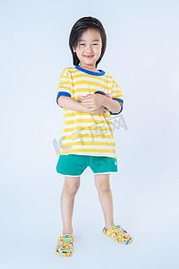 夏日儿童白天站着的男孩室内白背景抱着马卡龙摄影图配图